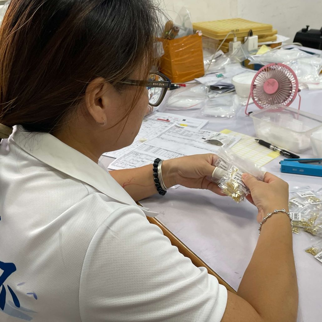 Jewelry factory worker packing finished s925 silver jewelry, pre‑shipment quality inspection in workshop